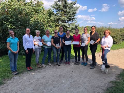 Gruppenfoto im Freien: mehrere Frauen mit Urkunden, daneben ein kleiner Hund